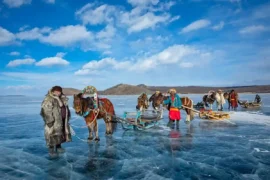 蒙古冬季旅遊：當地牧民穿著傳統服飾在結冰湖面上騎馬，蒙古9日私人小包團深度體驗