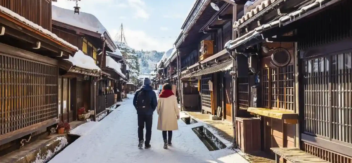 飛驒高山老街（上三之町）的冬季雪景，一對情侶漫步於保留著江戶時代風情的傳統木造建築街道中。