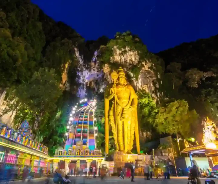 馬來西亞黑風洞夜景,壯觀的金身室建陀神像與亮起燈光的彩虹階梯,展現濃厚的印度教文化氛圍。