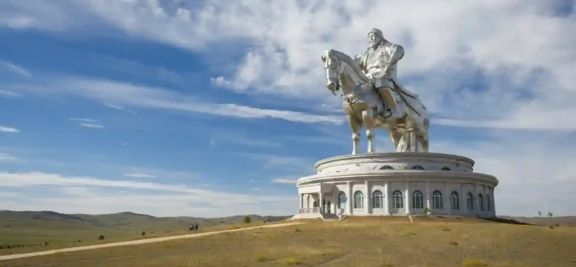 蒙古成吉思汗騎馬雕像，巨大的不鏽鋼雕像矗立在廣闊的草原上，藍天白雲下展現宏偉氣勢。