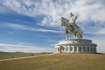 蒙古成吉思汗騎馬雕像，巨大的不鏽鋼雕像矗立在廣闊的草原上，藍天白雲下展現宏偉氣勢。